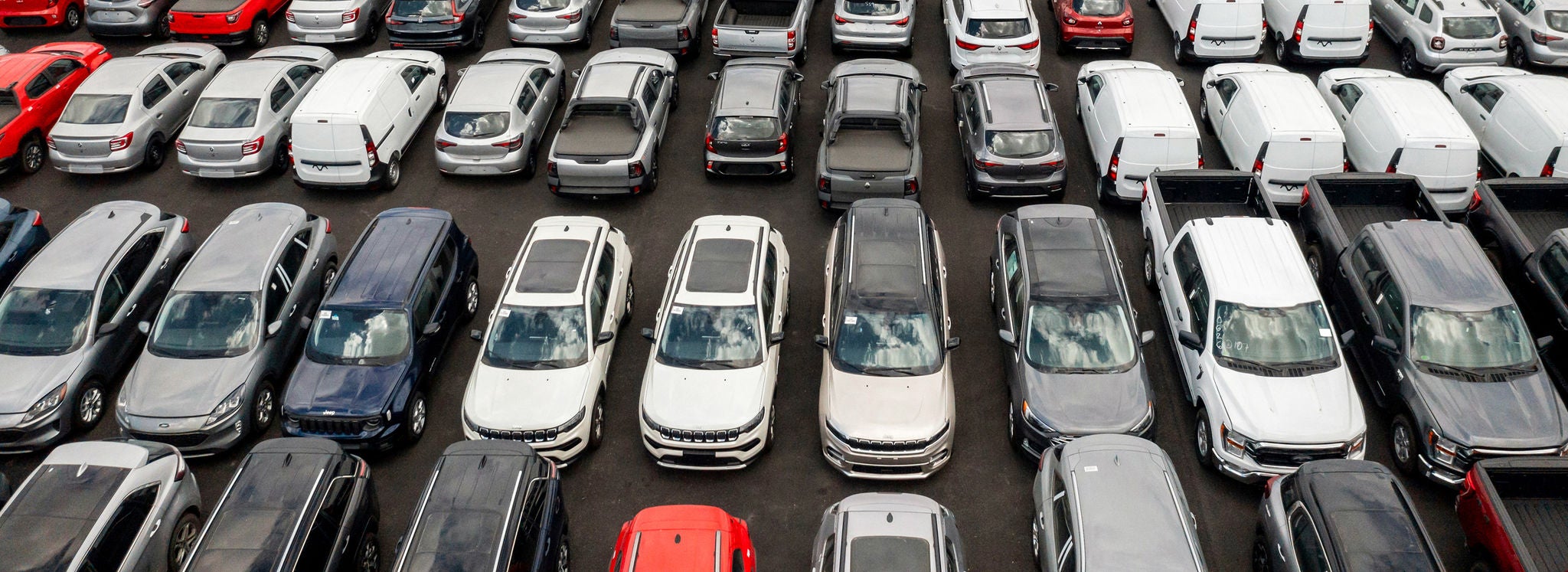 An aerial shot of finished vehicles parked on an automobile transport rail